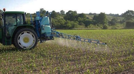 Tractor tratando un campo de cultivo